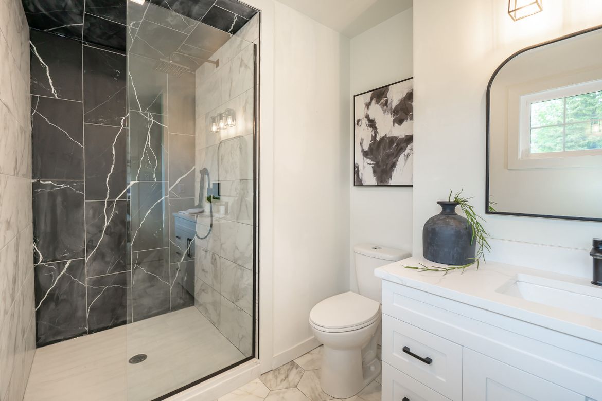 Bathroom with a glass walk-in shower and marble-look tile